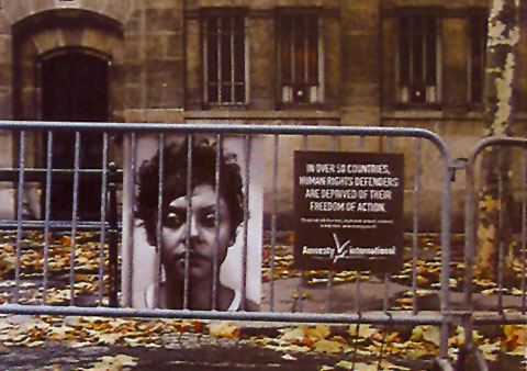 Ad showing a portrait of an individual behind a public fence