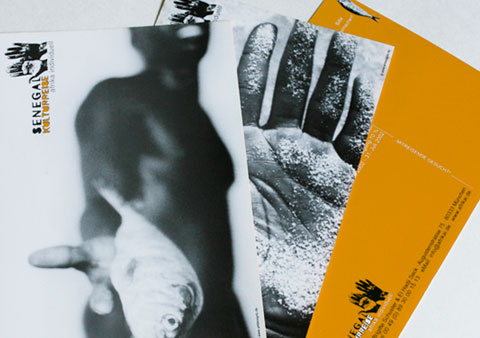 2 postcards of the series Senegal cultural trip with a b/w image of a colored man and a hand of a colored man and the back of these postcards