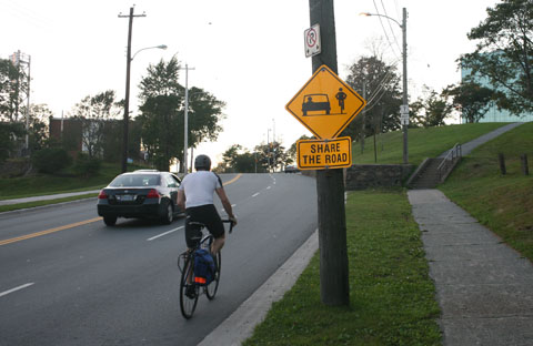 Sign on street promoting drivers and bikers sharing the street