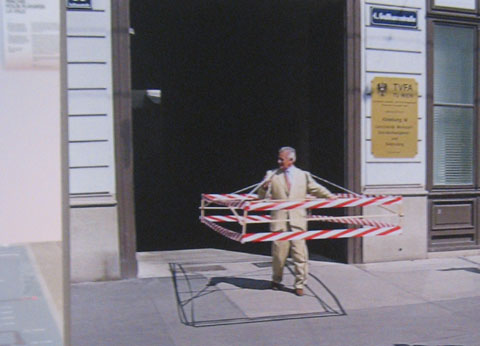 Exhibition wall featuring a project where a person takes on the size of a car