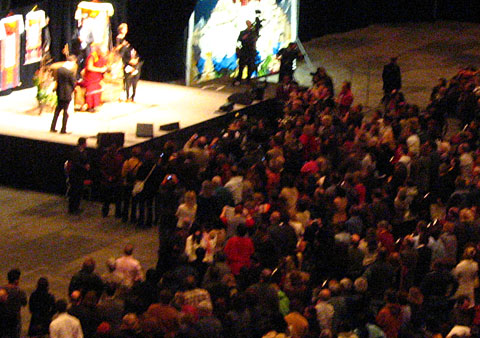 Dalai Lama on stage surrounded by a crowed of people during the conference in Ottawa