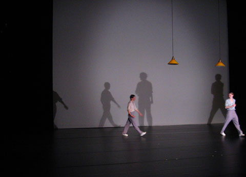 Two performers and their silhouettes on stage