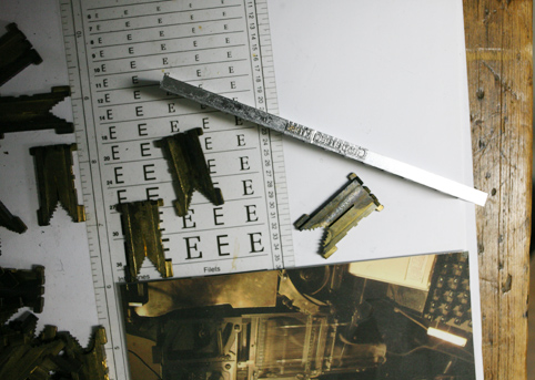 Line of letters made by a linotype machine and other objects on a table