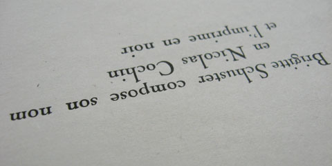 The text 'Brigitte Schuster compose son nom en Nicolas Cochin' on a paper sheet