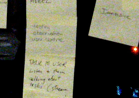 detail of post-it of all class members glued on a glass wall