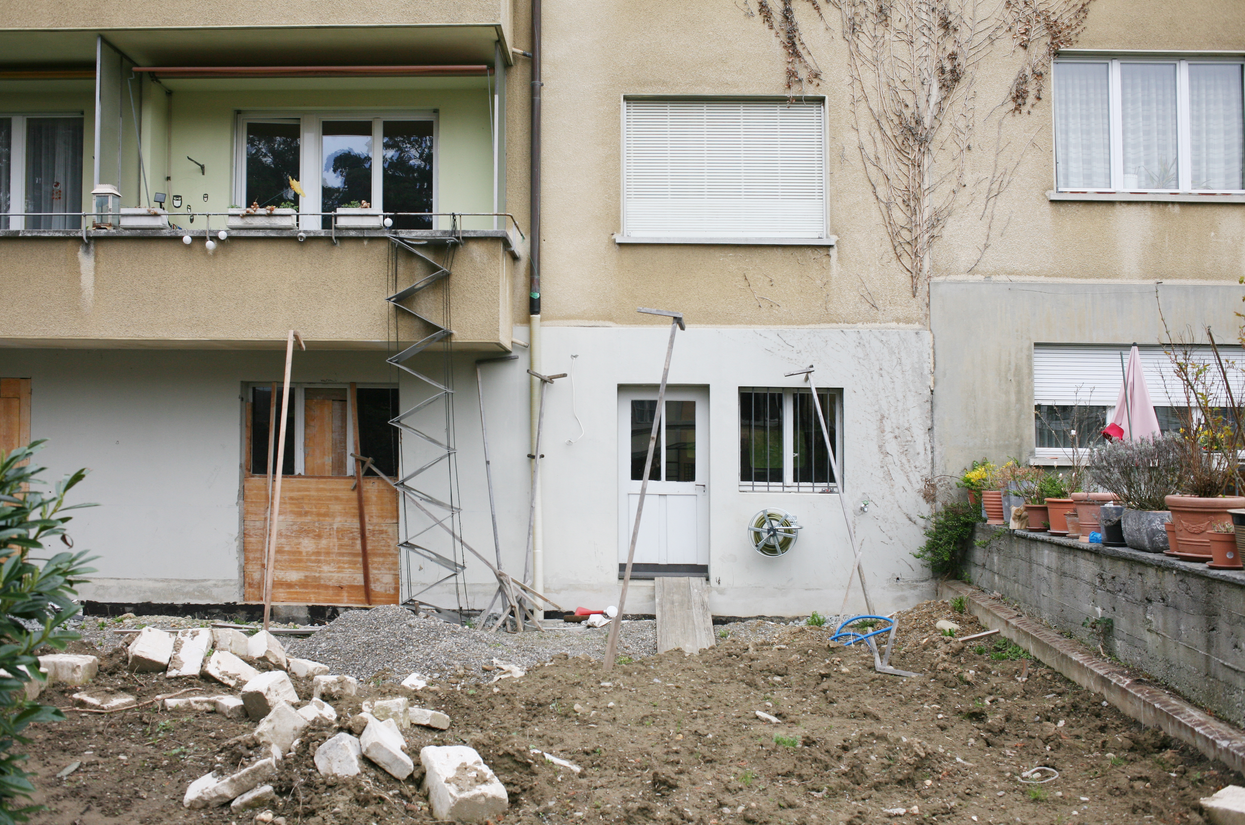 backyard in construction with building to which a cat ladder is attached