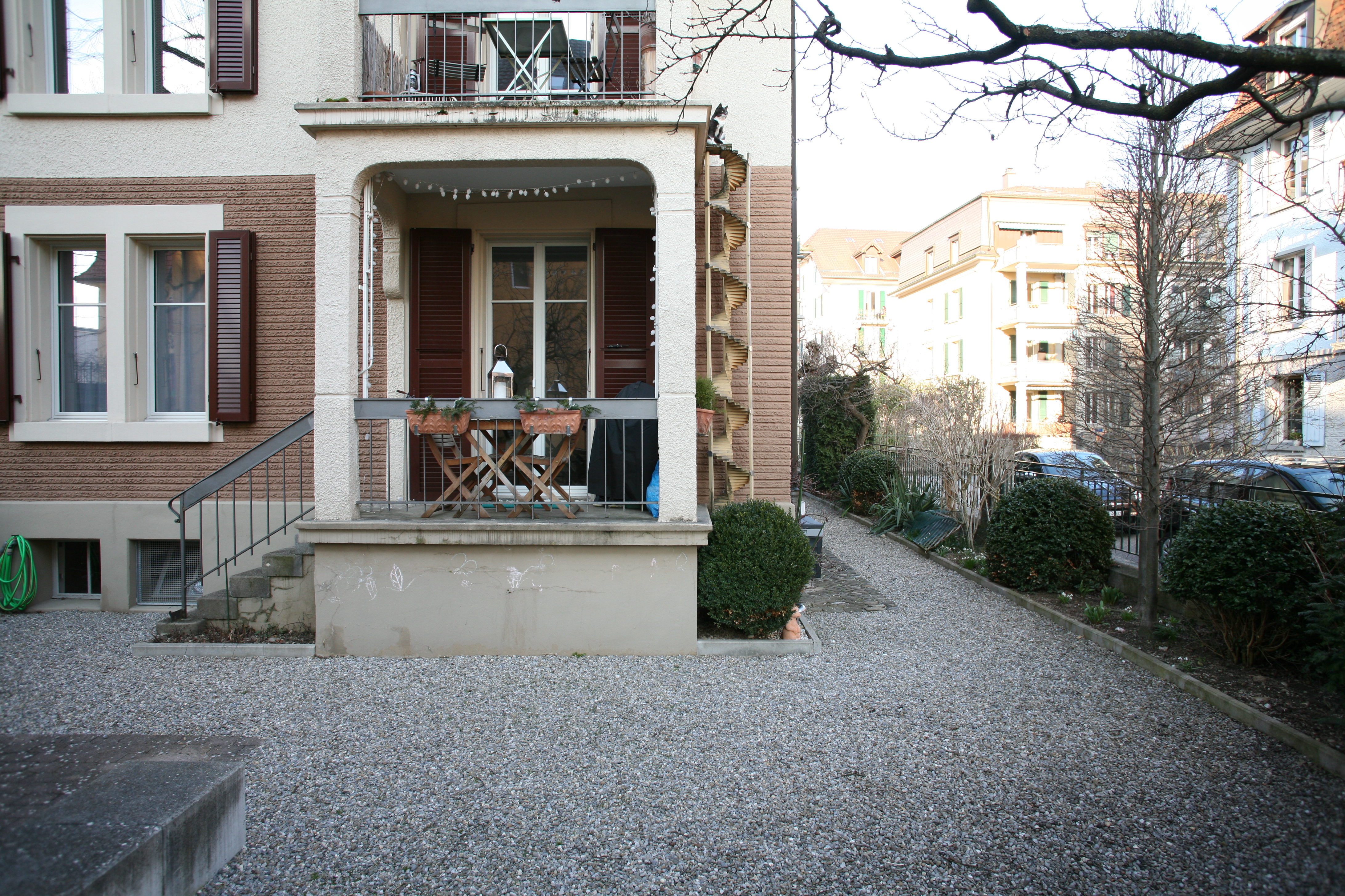 House front with balcony with a spiral cat ladder on the right