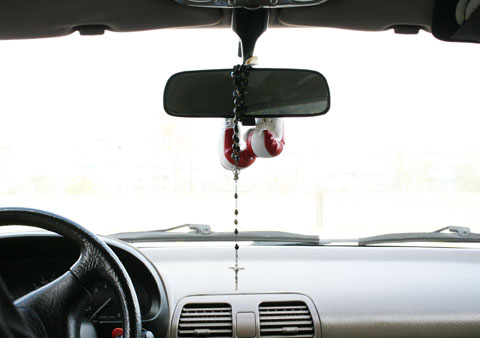 Chaplet and little boxing gloves on the car mirror space